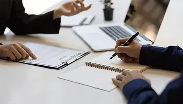 話し合いながらメモを取る人